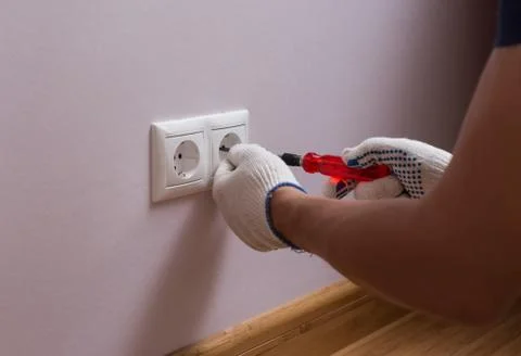 Electrician installing a wall power socket, close up photo Stock Photos