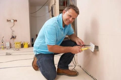 Electrician Installing Wall Socket Foto stock