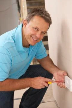 Electrician Installing Wall Socket Foto stock