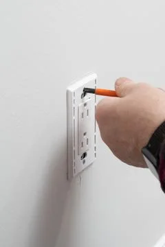 An electrician installs new current socket Stock Photos
