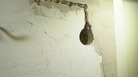 The electrician installs a round mounting box in the hole in the wall Stock Footage 84174707