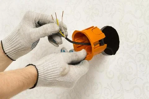 Electrician installs the socket box Stock Photos