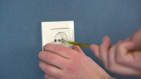 The electrician installs the socket on the wall with a special screwdriver Stock Footage 151999337