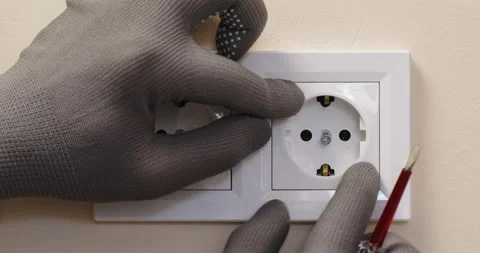 Electrician installs white socket in beige bedroom wall 動画素材 201488130