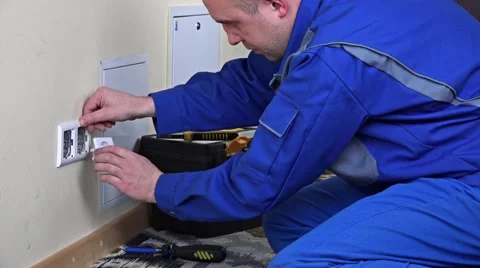 Electrician man installing a wall power socket Stock Footage 67872317