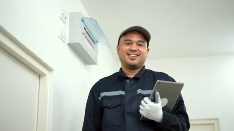 Electrician man in uniform using tablet for maintenance or fixing switches. Video stock 234259572