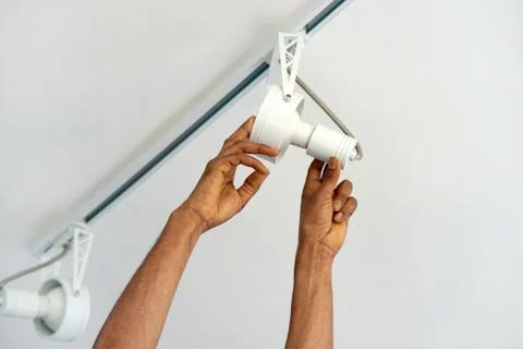 Electrician man worker installing a ceiling LED spotlight Stock Photos