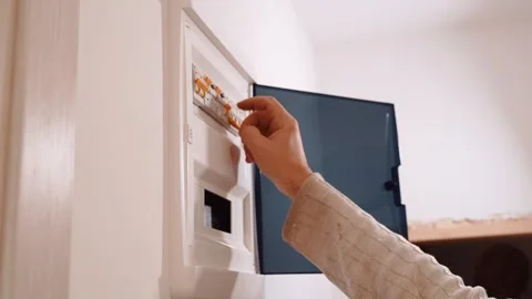 Electrician Opening Electrical Panel and Switching Off Circuit Breakers at Home Stock Footage 348061614