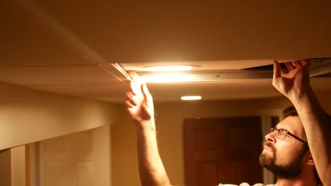 Electrician or Plumber moves Ceiling Tile into Place Stock Footage 324684873