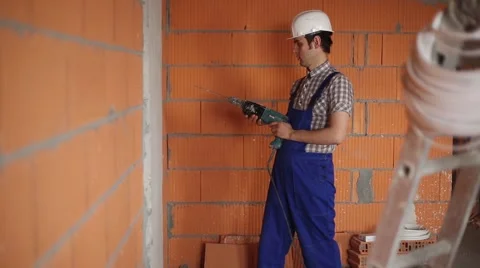 The electrician performs electrical installation using a drill Stock Footage 61696008