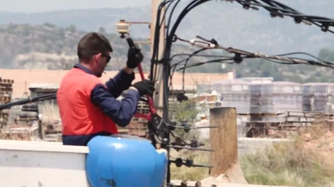An electrician performs maintenance on power lines,from an elevator in heat Stock Footage 276901602