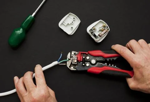 Electrician with plug and wire stripper Stock Photos