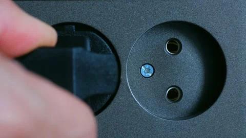 Electrician plugging a black plug into a grey wall socket Stock Footage 296747606