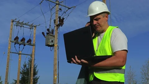 Electrician with portable computer talking on smart phone Video stock 95356238