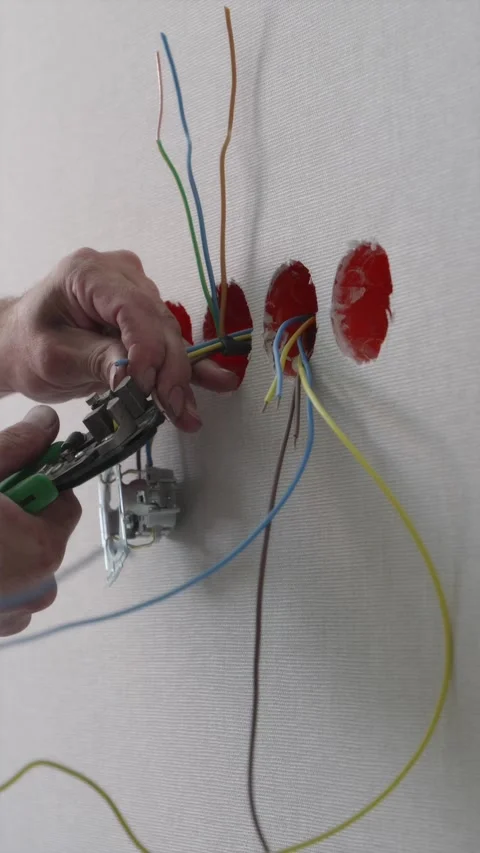 Electrician preparing electrical cables in row of wall socket boxes Video stock 345039420