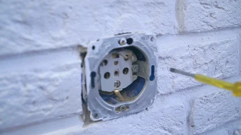 The electrician puts a screwdriver in the socket and checks whether there Stock Footage 120287414