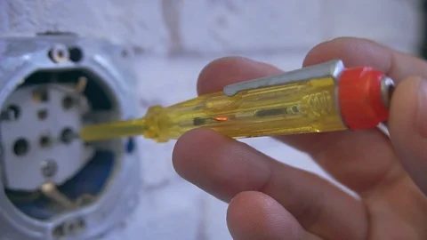 The electrician puts a screwdriver in the socket and checks the current. Stock Footage 120287416