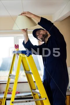 Electrician Repairing A Ceiling Lamp