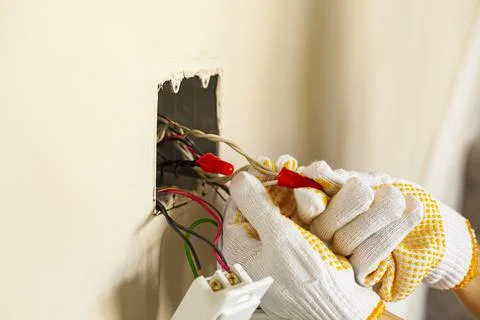 An electrician is replacing a wall switch. A DIY project concept. High voltag Stock Photos