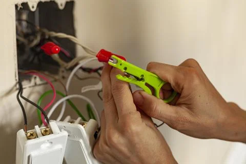 An electrician is replacing a wall switch. A DIY project concept. High voltag Stock Photos