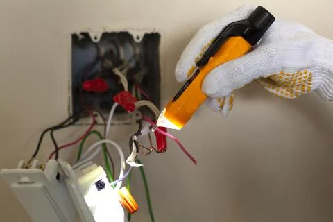 An electrician is replacing a wall switch. A DIY project concept. High voltag Stock Photos