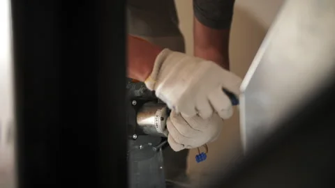 Electrician securing cable clamp with a screwdriver Stock Footage 296706153