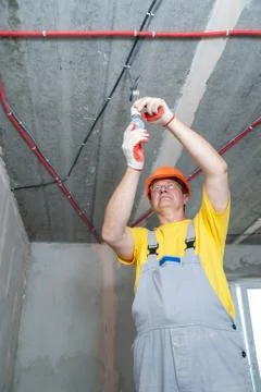 The electrician is setting a bulb. Stock Photos