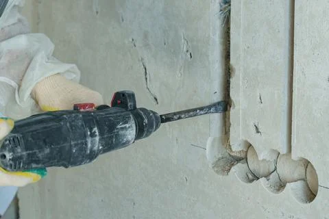 Electrician skillfully chasing electrical wiring during construction work Stock Photos