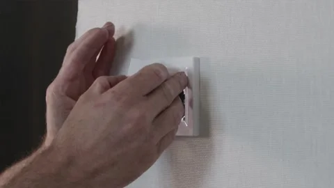 Electrician snapping on light switch cover and testing toggle button response Video stock 345039410