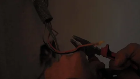 Electrician stripping and preparing red and black power cables for equipment Stock Footage 110771452