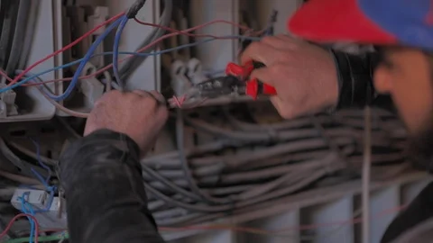 Electrician stripping and preparing red and black power cables for equipment Video stock 110771454