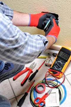 Electrician technician at work with safety equipment on a residential electri Stock Photos