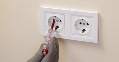 Electrician uses indicator to control voltage in socket Stockbeeldmateriaal 201606141