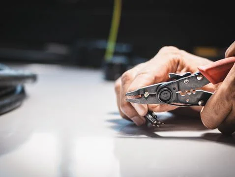 Electrician is using electrical stripping pliers Stock Photos