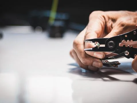 Electrician is using electrical stripping pliers Stock Photos