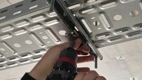 Electrician using power screwdriver on metal cable tray slow motion Stock Footage 341426908