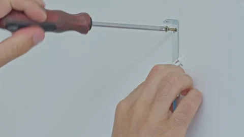 Electrician using screwdriver to install wall bracket near electrical wires Stock Footage 317022506