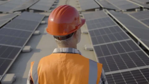 Electrician walking on rooftop solar panel array back view tracking shot 스톡 동영상 278469082