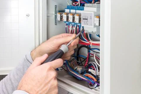 Electrician at work on an electrical panel Stock Photos