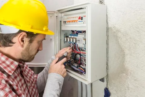 Electrician at work on an electrical panel 库存照片