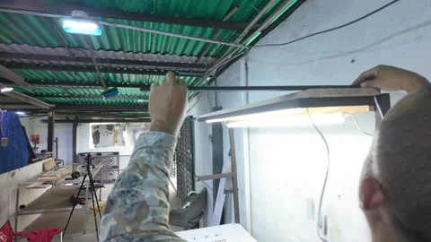 Electrician work. Latin Handyman installing light cables in furniture inside 動画素材 313474077