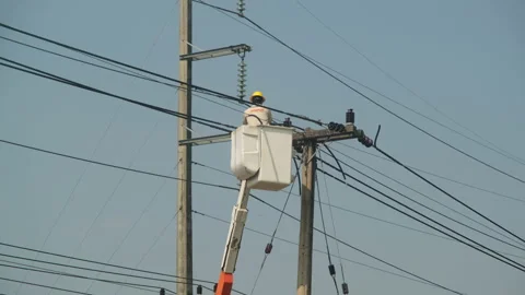 Electrician worker working on an electric pole to install and repair wires. Stock Footage 170871422