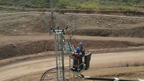 Electrician workers installating power line pylon using construction equipment 스톡 동영상 253985796