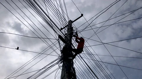 Electrician Working on electric pylon surrounded by tangled dangerous wires Stock Footage 137220557