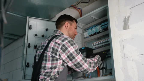 Electrician working on electrical panel installing a new device Stock Footage 314562004