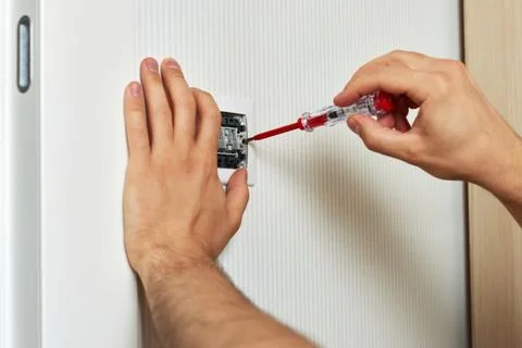 Electrician working on light switch using screwdriver Stock Photos