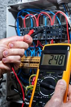 Electrician working on a residential electrical panel. Electricity. Stock Photos