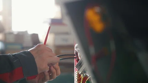 Electrician's hands installing energy system on machinery industry Stock Footage 85903534