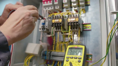 Electricians hands testing current electric in control panel. Electrician Stock Footage 158931786