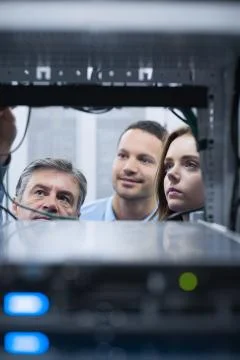 Electricians looking into empty server towers Stock Photos